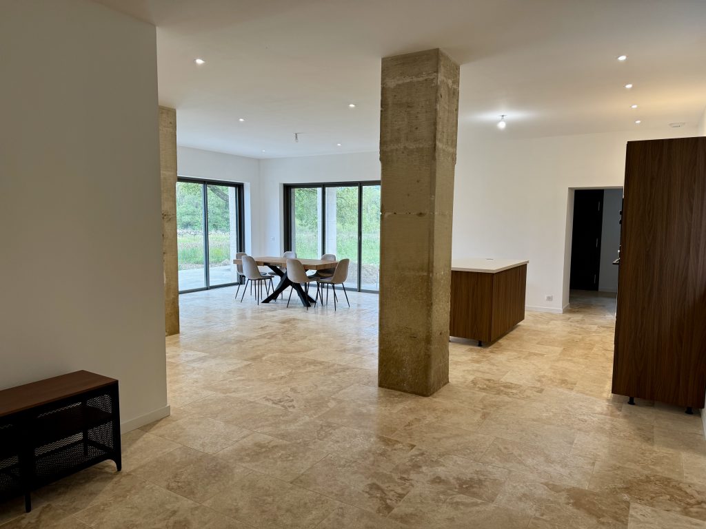 Pièce de vie rénovée avec poutre et parquet clair