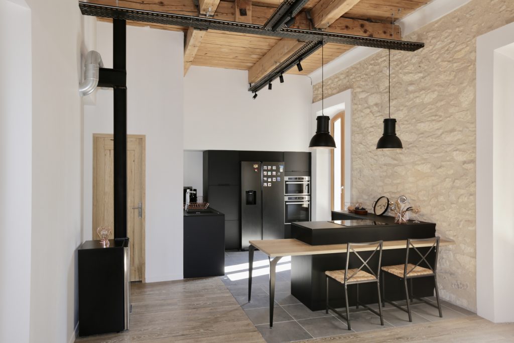 Cuisine noire avec îlot central dans une maison rénovée